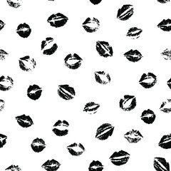 Vector seamless black and white pattern of kissing lips stamps randomly scattered on white background.