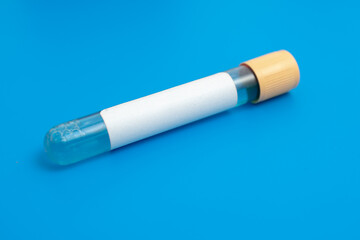 Test tube with empty label  to biological sample for medical laboratory research on blue background