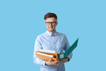 Fototapeta na wymiar Man with folders on color background