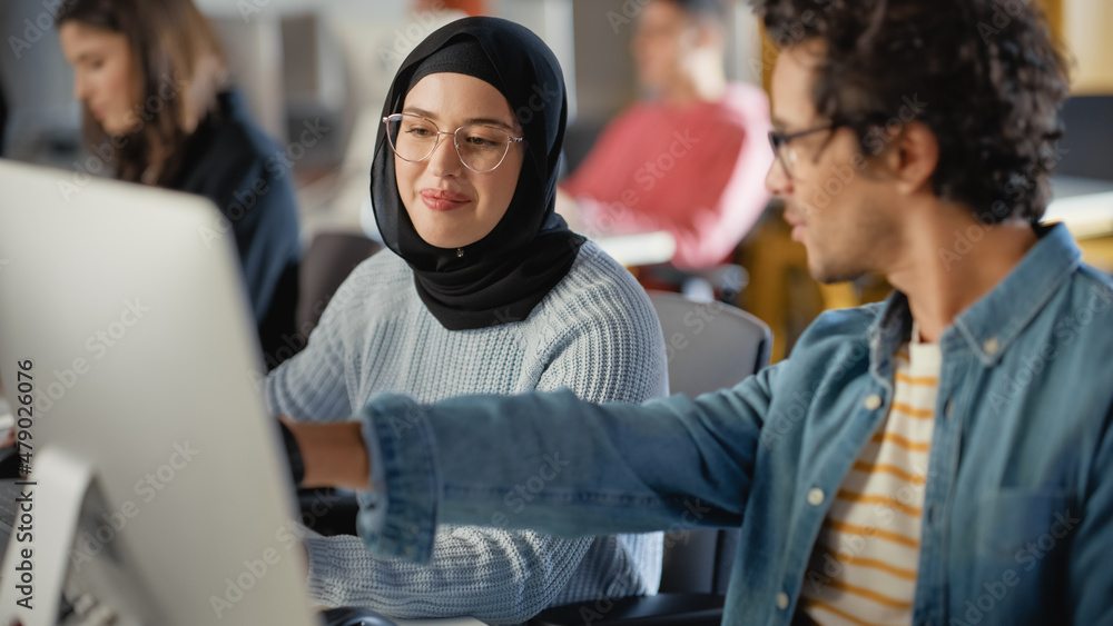 Poster Female Muslim Student Wearing Hijab, Studying in Modern University with Diverse Multiethnic Classmates. She Asks Scholar a Question in College Room. Learning Software Engineering or Computer Science.