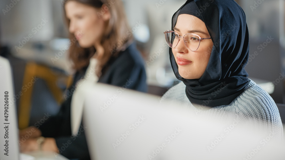 Aufkleber beautiful portrait of a female muslim student in hijab, studying in university. she works on desktop