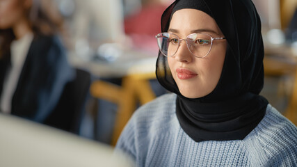 Beautiful Portrait of a Female Muslim Student in Hijab, Studying in University. She Works on...