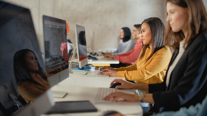 Diverse Multiethnic Group of Female and Male Students Sitting in College Room, Learning Computer Science. Young Scholars Study Information Technology on Computers in University, Writing Code in Class.