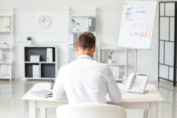 Young businessman working at table in office