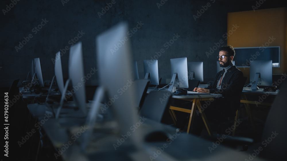 Aufkleber concentrated male student sitting alone in college informatics room, working late evenings on comput