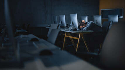 Stressed Male Student Sitting Alone in College Informatics Room, Working Late Evenings on Computer Science Project. Tired Scholar Study IT on Computer in University, Writing Homework.