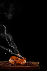 wax candle with burning wick and smoke, isolated on a black background