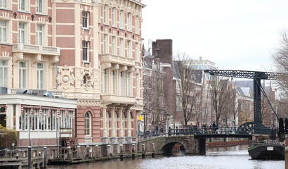 Naklejka premium Amsterdam Kloveniersburgwal Canal View with Metal Aluminiumbrug Bridge and Building Facades, Netherlands