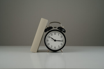 book leaning against black clock