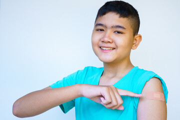 Portrait of rural Asian boy standing against white background looking camera smiling happily...