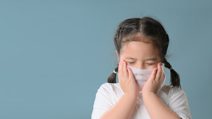 Little asian child girl sick and sad with sneezing on nose and cold cough on tissue paper because weak or virus and bacteria from dust weather.