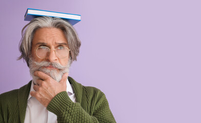 Thoughtful senior man with book on color background