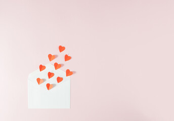 Red harts flying out of a white envelope - Valentine's Day love card. Minimal concept.