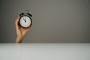 Hand holds black watch with grey background