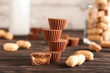Tasty chocolate candies with peanut butter on wooden background