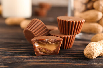 Tasty chocolate candies with peanut butter on wooden background, closeup
