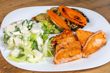 Grilled salmon fillet with green salad with yogurt sauce and grilled vegetables. restaurant dish. healthy dish