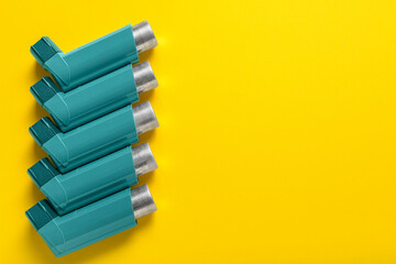 Asthma inhalers on yellow background