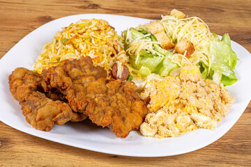 Breaded beef steak served with caesar salad, biro biro rice and egg farofa. Brazilian food usually served as an executive dish