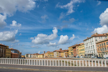 Fototapeta na wymiar Pisa, Italy, September 2015, bridge over the Arno river, embankment with colorful houses