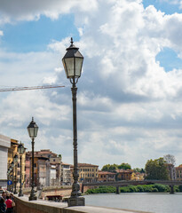 Pisa, Italy, September 2015, embankment of the Arno river with colorful houses and lanterns