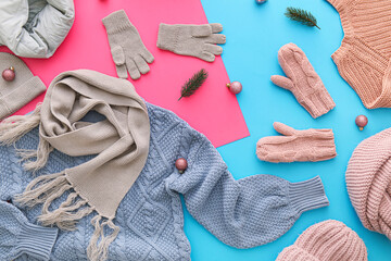 Stylish warm clothes, shoes and Christmas decor on color background