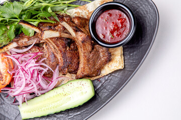 rack of lamb with fresh vegetables, onions, herbs on pita bread