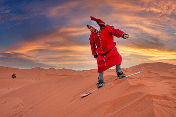 Man in traditional clothes sand boarding over the dunes in sahara desert during dusk, Man sand boarding down the dune
