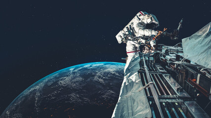 Astronaut spaceman do spacewalk while working for spaceflight mission at space station . Astronaut wear full spacesuit for operation . Elements of this image furnished by NASA space astronaut photos . - Powered by Adobe