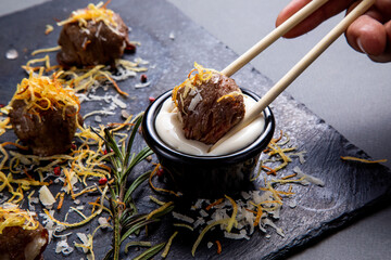 dips the meat appetizer in white sauce