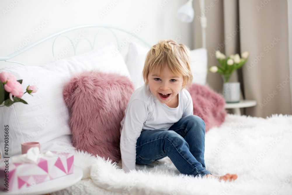 Sticker Cute child, lying in bed, reading book