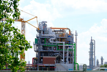 large plant, factory, modern chemical production, smoke flies from the pipes into the blue sky, steam, the concept of environmental pollution, harmful emissions into the atmosphere