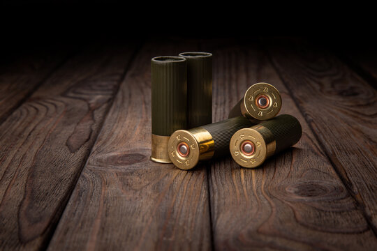 Shotgun cartridges on a brown wooden table. Ammunition for 12 gauge smoothbore weapons.