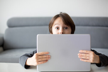 Preteen child, hiding behind notebook, online education, games and fun for kid, bad influence