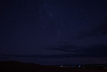 Beautiful view of stars over sand in sahara desert at night, Silhouette of desert landscape with starry sky at night