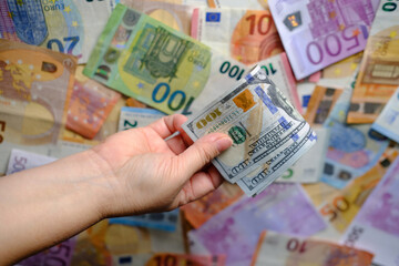 closeup female hands hold american money, count dollars against background of paper euro banknotes, concept of cash, payments, savings, banking, save for vacation, exchange and cashing currency