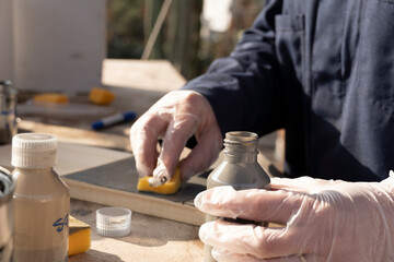 Mujer pintando madera con esponja