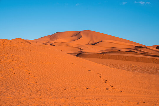 Beautiful view of footprints on sand dunes in sahara desert against clear sky, Footsteps on sand dunes in desert landscape © ingusk