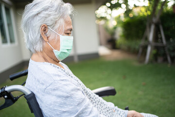 Asian senior or elderly old lady woman on wheelchair and wearing a face mask for protect safety...