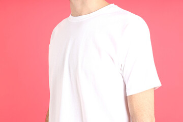 Man in blank white t-shirt on pink background