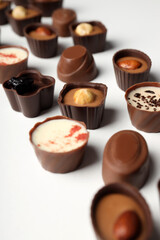 Flat lay composition with chocolate candies on white background