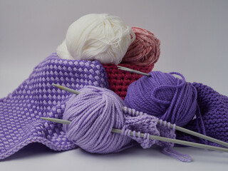 Wool yarn in different colors with wooden double point needles. The needles are being used for knitting socks, mittens or other projects joined in the round.