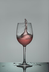 red wine splash. Rose wine glass where the liquid wants to come out of the glass in a splash.