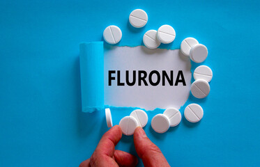 Covid-19 corona and flu flurona symbol. The word flurona appearing behind torn blue paper. White...