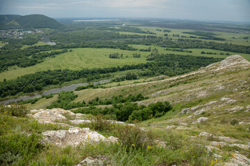 View from the old limestone mountain to the forest. Summer, cloudy.
