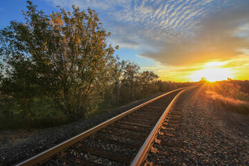 Fototapeta na wymiar Train Tracks Leading into the Setting Down Sun
