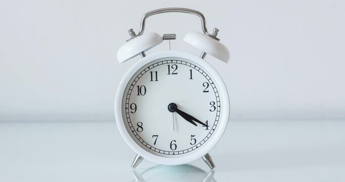Alarm clock running time lapse on white background
