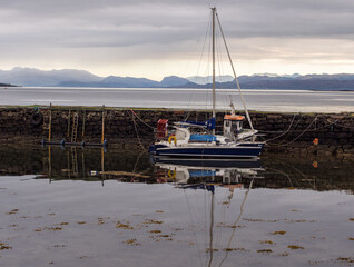 Beautiful reflections of a yacht in high tide at Broadford, Isle of Skye, Scotland, uk