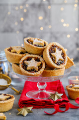 Christmas fruit mince pies on a glass stand.  Shortcrust pastry pies stuffed with raisins, nuts, apples. Selective focus © Olga Romankova