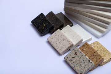 Samples of natural granite, marble, quartz stone, countertops and a sample of natural parquet. Model made of stones, closeup. Modern colored slabs made of natural stone.